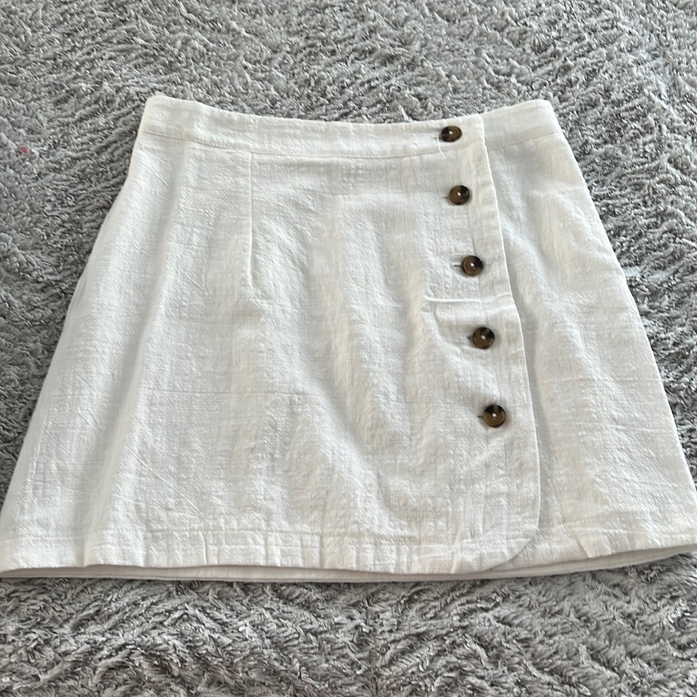 Altard’s state skirt in white with buttons detail on the side .